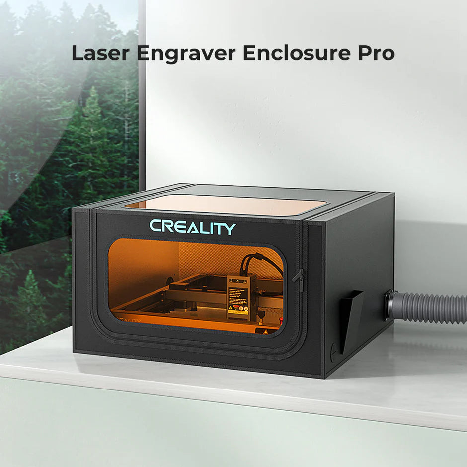 A CrealityFalcon Falcon2 40W Laser Engraver and Cutter Ultimate Engraving Package sits on a white surface. The black rectangular enclosure features a large, transparent orange viewing window on the front and a hose attached on the side. Text above reads "Laser Engraver Enclosure Pro with Ultra-fine Carving and Cutting. A CrealityFalcon Falcon2 40W Laser Engraver and Cutter Ultimate Engraving Package sits on a white surface. The black rectangular enclosure features a large, transparent orange viewing window on the front and a hose attached on the side. Text above reads "Laser Engraver Enclosure Pro with Ultra-fine Carving and Cutting.