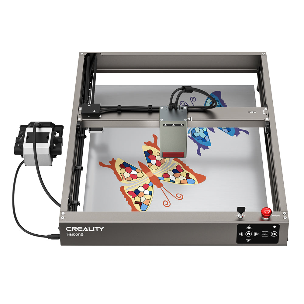 A CrealityFalcon Falcon2 40W Laser Engraver and Cutter Ultimate Engraving Package is shown with a metal frame and a control box attached by cables. The machine, boasting a 40W laser output, is actively engraving a colorful butterfly design on a flat surface at an impressive 25000mm/min cutting speed. It features a display panel and control buttons on its front edge.