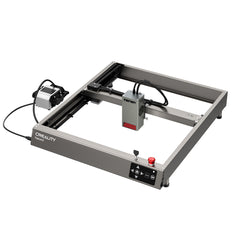 A CrealityFalcon Falcon2 40W Laser Engraver and Cutter Ultimate Engraving Package is shown from a slightly elevated angle. The device features a square frame with a 40W laser output module mounted on a movable arm. Control buttons, including a red emergency stop button, are on the front panel. Capable of 25000mm/min cutting speed, the engraver connects to a power source.