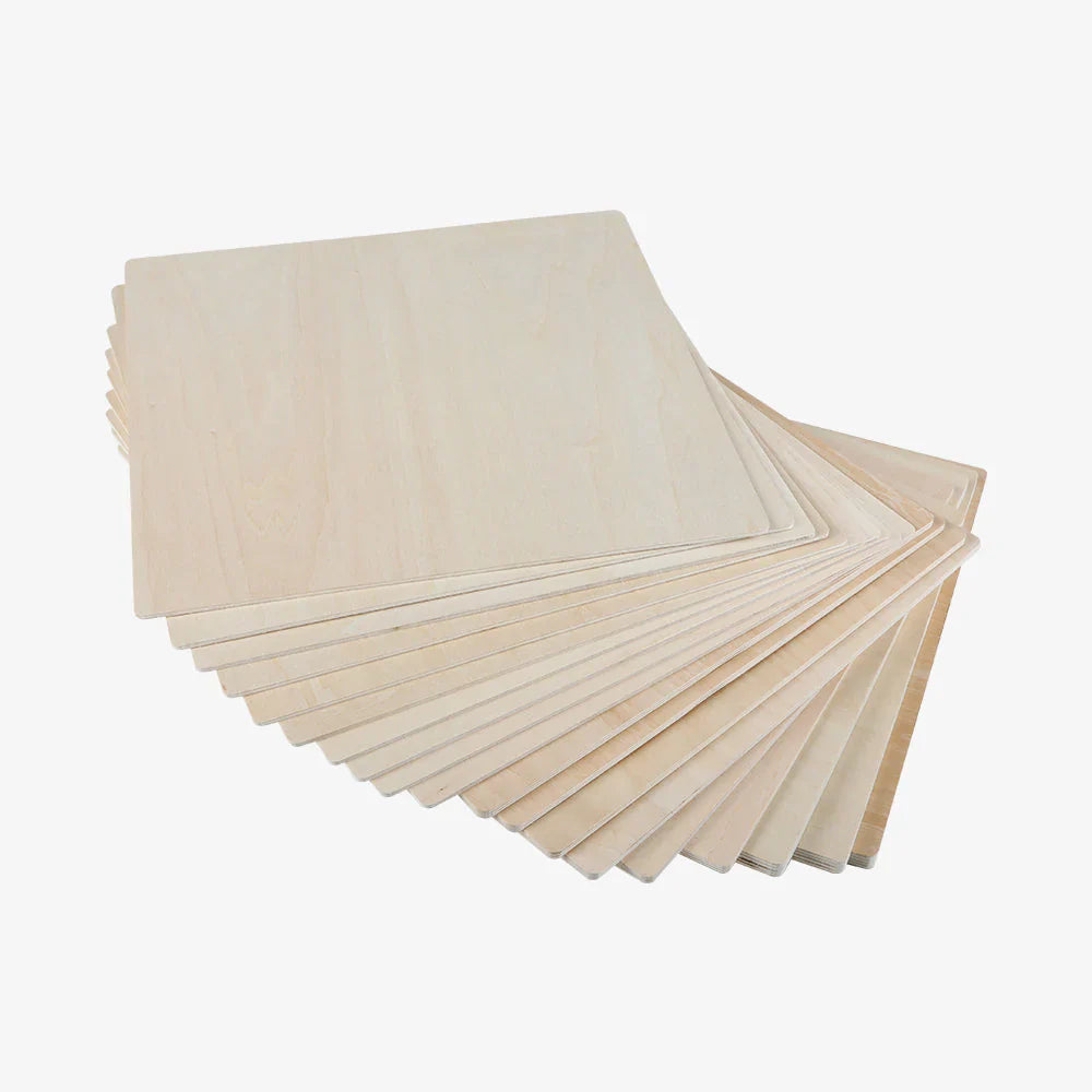 A stack of thin, square, light-colored basswood sheets from the CrealityFalcon Autumn Crafting Package is arranged in a slightly fanned-out pattern. The wood grain is visible, making them ideal for laser engraving. The background is plain white.